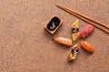 Assorted sushi set on a brown stone background. Japanese food sushi, soy sauce, chopsticks. Top view, copy space Royalty Free Stock Photo