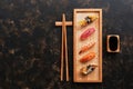 Assorted sushi set on a dark rustic background. Japanese food sushi on a wooden plate, soy sauce, chopsticks. Top view,copy space Royalty Free Stock Photo