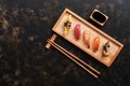 Assorted sushi set on a dark rustic background. Japanese food sushi on a wooden plate, soy sauce, chopsticks. Top view. Sushi Royalty Free Stock Photo