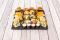 Assorted sushi tray with nori seaweed maki, uramaki california roll with masago roe, raw salmon nigiri, flambÃÂ© salmon, crispy Royalty Free Stock Photo