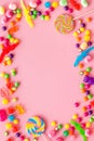 Assorted sweets and lollipop frame on pink background top view space for text Royalty Free Stock Photo