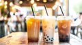 Assorted tapioca bubble teas on blurred coffee shop background, variety of refreshing drink choices.