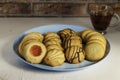 Assorted tea pastes on a blue plate and tea cup on brick background