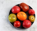 Assorted tomatoes on a round plate on a light gray background