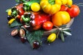 Assorted tomatoes and vegetables on dark background. Photo for your design