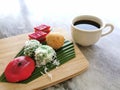 Assorted traditional malay dessert called kuih-muih served with coffee on the table.