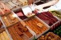 Assorted Turkish Delight or lokum Sweets on Turkish bazaar market. Trader making box with lokum rolls for tourist