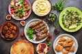 Assorted variety of Arabic and Middle Eastern food on a dark rustic background. Hummus,tabbouleh salad, salad Fattoush,pita,meat