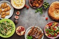 Assorted variety of Arabic and Middle Eastern food on a dark rustic background. Hummus,tabbouleh salad, Fattoush salad,pita,meat