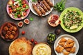 Assorted variety of Arabic and Middle Eastern food on a dark rustic background. Hummus,tabbouleh salad, salad Fattoush,pita,meat