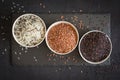 Assorted of variety of gourmet rice in bowls On black background. Top view Royalty Free Stock Photo
