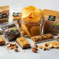 Assorted vegan snacks are arranged on a table. The setup includes a glass jar filled