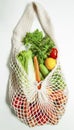 Assorted vegetables in mesh grocery bag isolated on white background Royalty Free Stock Photo