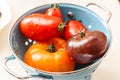 Assorted wet tomatoes draining in a colander