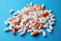 Assorted white and orange capsules on blue background