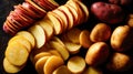 Assorted whole and sliced potatoes on a dark rustic surface, fresh raw ingredients for traditional cuisine Royalty Free Stock Photo