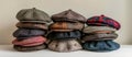 Assorted Wool Newsboy Caps Piled on White Table