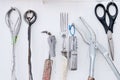 Assortment of antique tools, including scissors, are displayed on a white wall