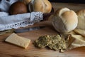 Assortment of baked bread rolls including wholemeal and rustic white, fresh cheese slices, and multigrain crackers Royalty Free Stock Photo