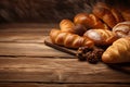Assortment of baked bread and bread rolls, loaves, buns, pastry on rustic black bakery table counter, copy space