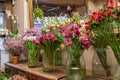 Assortment of beautiful flowers in shop for sale, placed in vases in flower shop. Tulips, roses and limonium Royalty Free Stock Photo