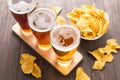 Assortment of beer glasses with nachos chips on a wooden table Royalty Free Stock Photo