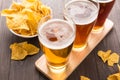 Assortment of beer glasses with nachos chips on a wooden table Royalty Free Stock Photo