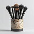 Assortment of Black Makeup Brushes with Textured Holder on White Background Royalty Free Stock Photo