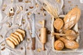 Assortment of bread in basket and sliced bread on bread plate with bread knife and rolling pin Royalty Free Stock Photo