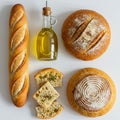 Assortment of breads and olive oil on a white surface. Includes a baguette with Royalty Free Stock Photo
