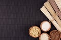 Assortment of bundles raw noodles with ingredient in wooden bowls on black striped mat background with copy space, top view. Royalty Free Stock Photo