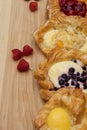 Assortment of cheese danishes puff pastry with blackberries, vanilla custard, cherry jam and fresh raspberries