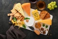 Assortment of cheese, honey, cracker, blueberries, grapes with red and white wine in glasses antipasto server on white marble boar Royalty Free Stock Photo