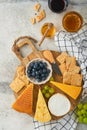Assortment of cheese, honey, cracker, blueberries, grapes with red and white wine in glasses antipasto server on white marble boar Royalty Free Stock Photo