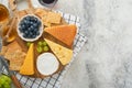 Assortment of cheese, honey, cracker, blueberries, grapes with red and white wine in glasses antipasto server on white marble boar Royalty Free Stock Photo