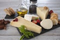 Assortment of cheese slices with fruits pepper and olive oil on wooden table Royalty Free Stock Photo