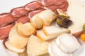 Assortment of cheeses and slices of cured pork loin.