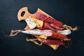 Assortment of cheeses and traditional sausages on a wooden background. Brie cheese, blue cheese, gorgonzola, fuete, salami. Royalty Free Stock Photo