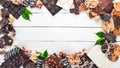 Assortment of chocolate with nuts, cookies and cocoa. On a white wooden background. Royalty Free Stock Photo