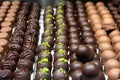 Assortment of chocolate pralines in pastry shop. Variety of sweet Swiss or Belgian candies in rows. Handmade desserts of