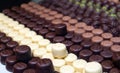 Assortment of chocolate pralines in pastry shop. Variety of sweet Swiss or Belgian candies in rows. Handmade desserts of