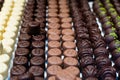 Assortment of chocolate pralines in pastry shop. Variety of sweet Swiss or Belgian candies in rows. Handmade desserts of