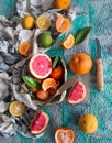 Assortment of citrus fruits, sliced and whole, with a knife on a blue background. Mixed tropical fruits lime, lemon, orange Royalty Free Stock Photo