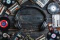 Assortment of classic vinyl records and headphones on a brick wall background, evoking musical nostalgia