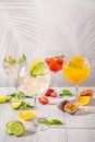 Assortment of cold lemonades in wine glasses on wooden table in morning sunlight