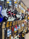 Assortment of colorful Acoustic electric guitars hanging on wall in a modern musical shop