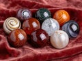 Assortment of colorful glass marbles on red velvet Royalty Free Stock Photo