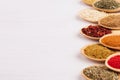 Assortment colorful powdered spices in bamboo spoons, copy space, closeup. Royalty Free Stock Photo