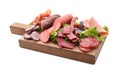 Assortment of delicious deli meats on wooden board, isolated on white Royalty Free Stock Photo