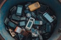An assortment of discarded mobile phones and gadgets in a blue trash bin. A journey through technology waste. A visual Royalty Free Stock Photo